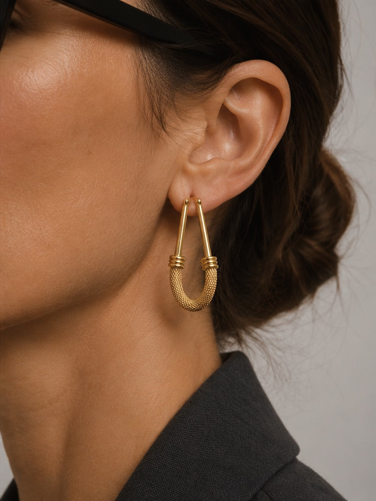 Time4Me gold elongated hoop earrings with textured detail worn by a woman