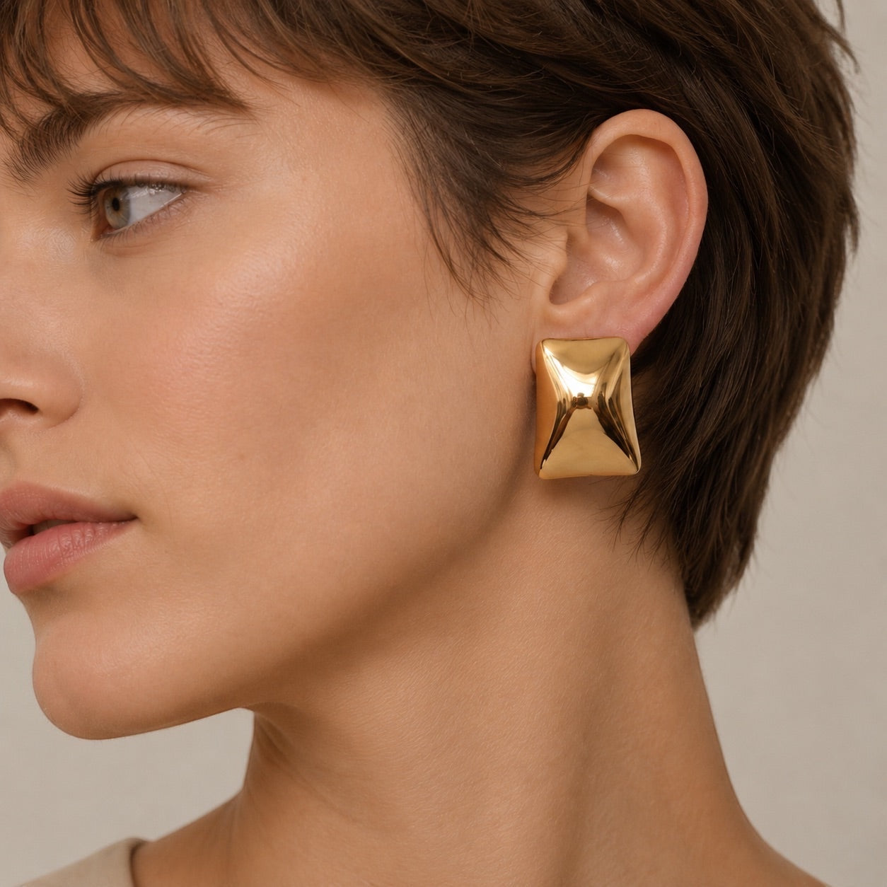 Time4Me gold rectangular stainless steel stud earrings worn by a woman with short hair