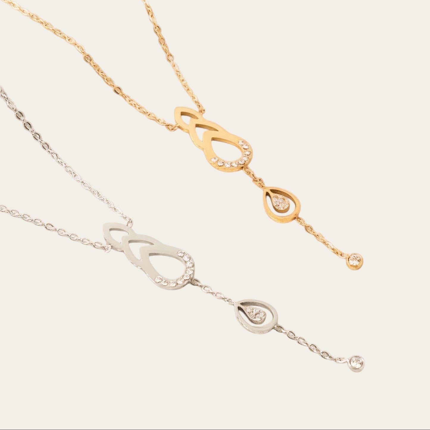 Time4Me gold and silver stainless steel necklaces with teardrop cutouts and sparkling rhinestone accents