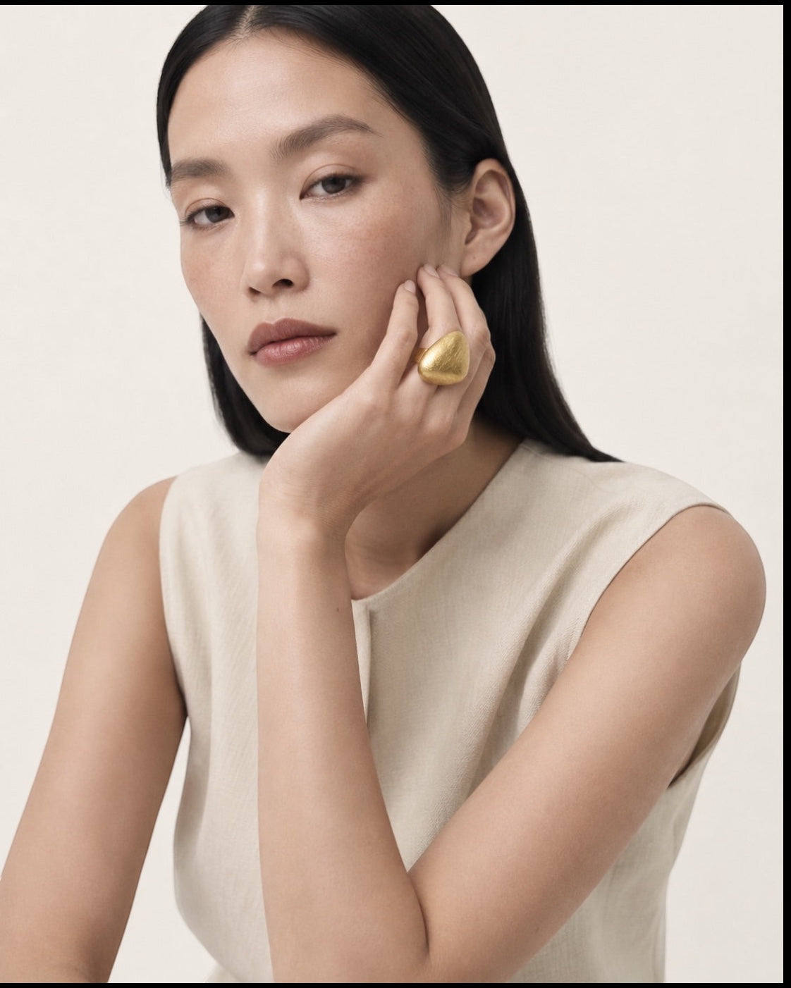 Time4Me adjustable gold brushed dome ring worn by a woman resting her chin on her hand