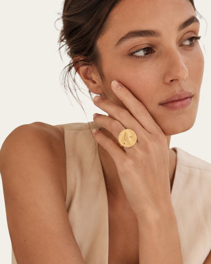 Time4Me adjustable gold brushed stainless steel ring with abstract face design worn on a woman's hand