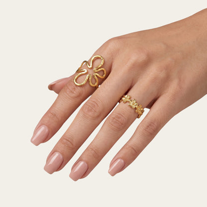 Time4Me adjustable gold stainless steel ring with a stylized flower design worn on a woman's hand