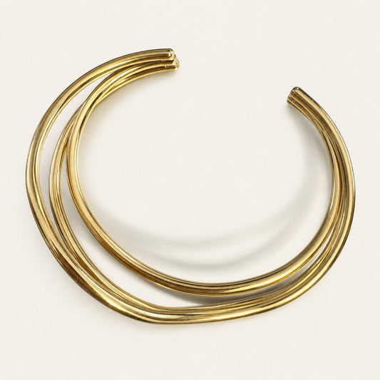 Time4Me gold-tone stainless steel cuff bracelet with a layered, crossed-line design on a white background.