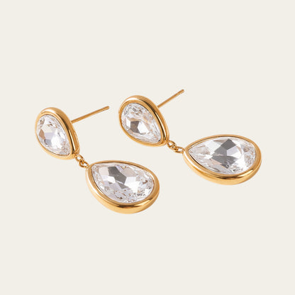 Time4Me long gold stainless steel earrings featuring two clear glass teardrop pendants on a neutral background