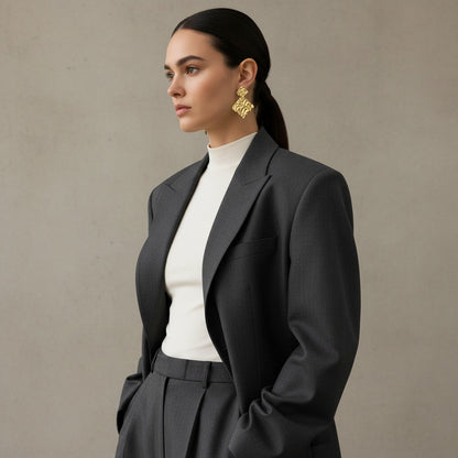 Time4Me gold hammered rhombus earrings worn by a woman in a grey blazer and white turtleneck