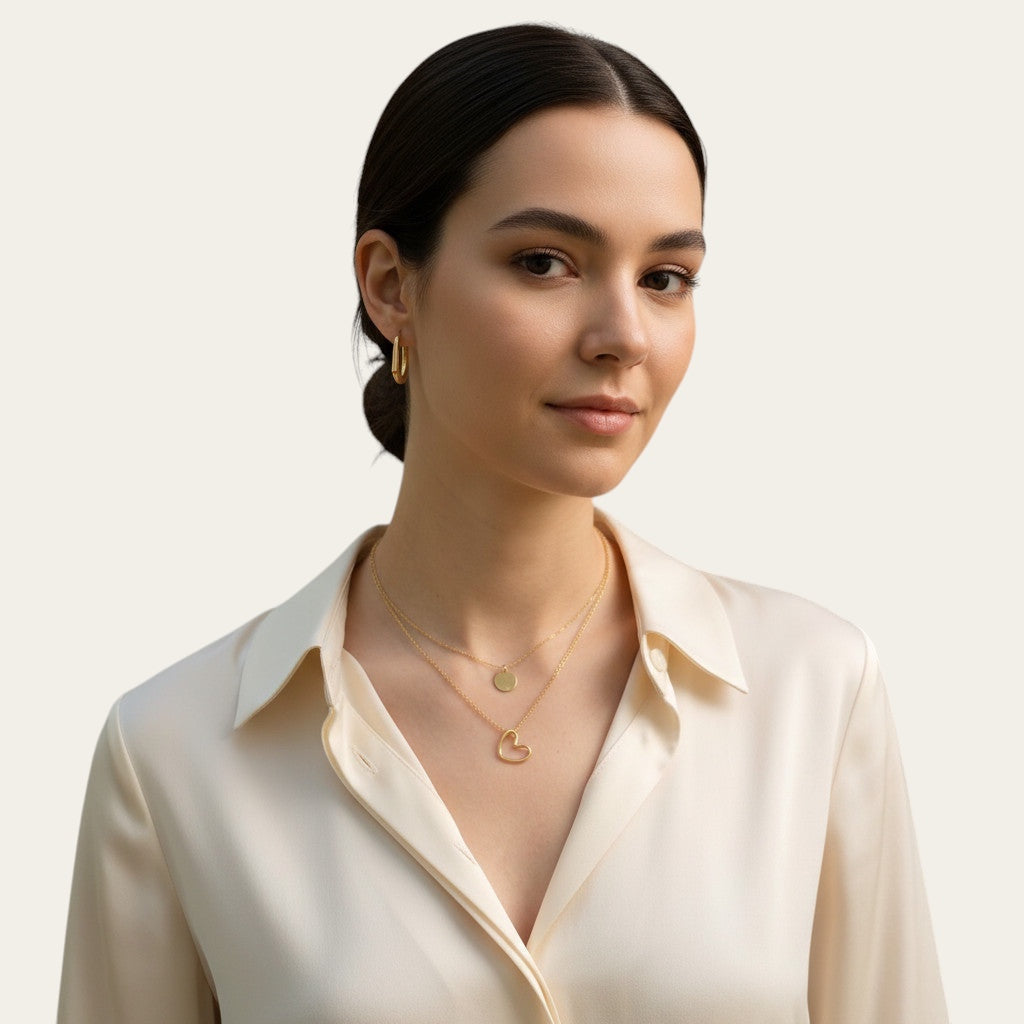 Time4Me gold layered necklace featuring a stylized heart pendant and a small disc charm worn by a woman
