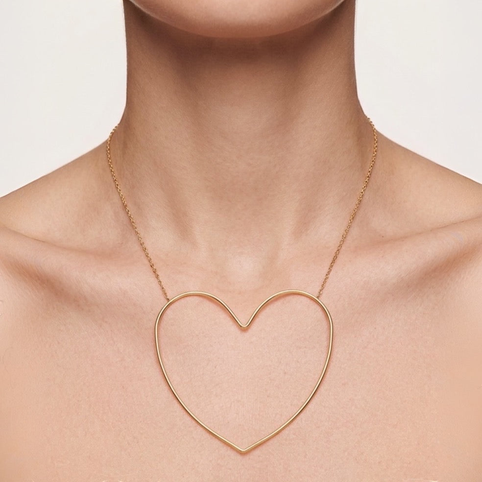 Time4Me gold-toned stainless steel necklace featuring a large minimalist stylized heart pendant on a delicate chain.