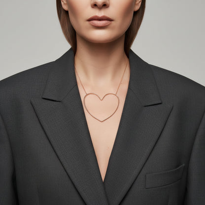 Time4Me gold-toned stainless steel necklace with a stylized open heart pendant worn over a dark grey blazer
