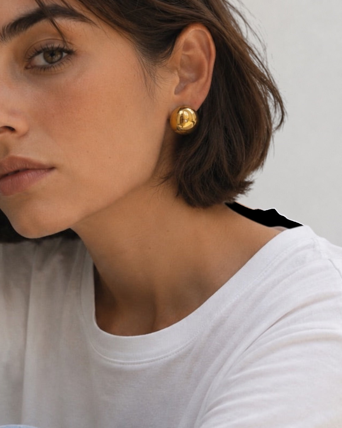 Time4Me gold hemisphere stud earrings worn by a woman in a white t-shirt, minimalist stainless steel jewelry
