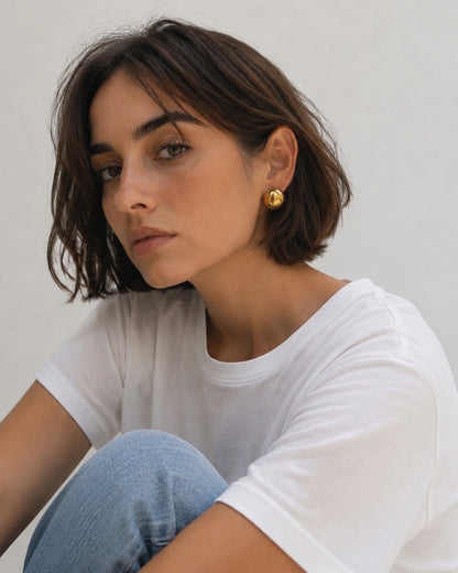 Time4Me gold hemisphere stud earrings worn by a woman with short brown hair, featuring a minimalist polished design.