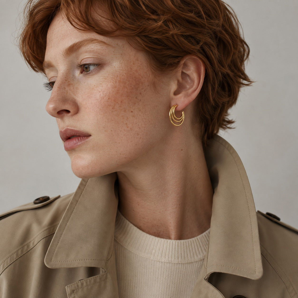 Time4Me gold hoop earrings worn by a woman with short red hair, featuring a minimalist triple-layered design.