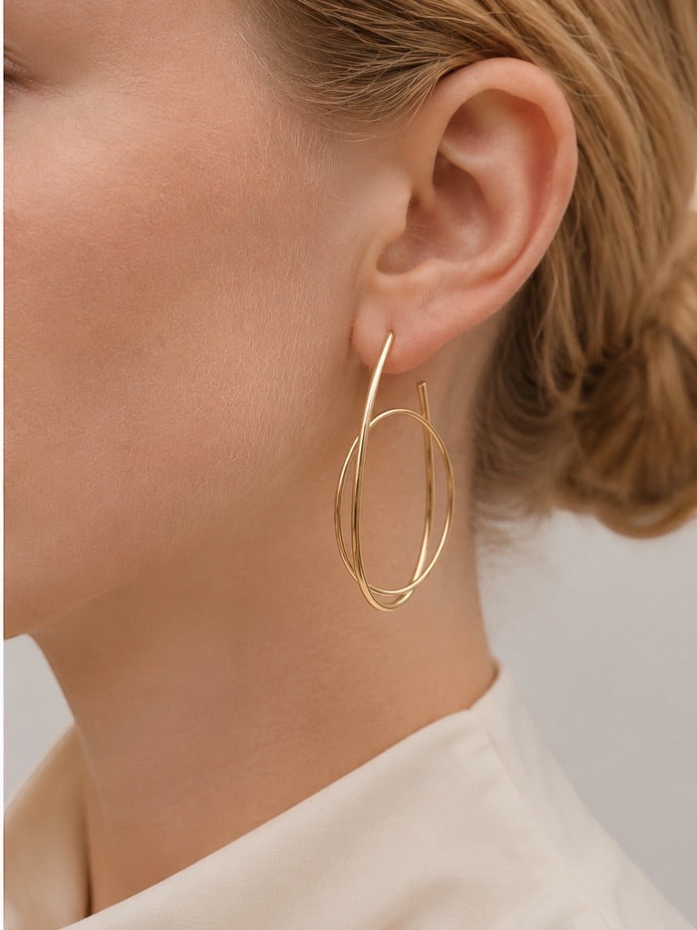 Time4Me gold hoop earrings featuring an elegant intertwined ring design worn by a woman