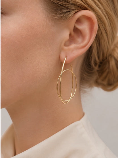Time4Me gold hoop earrings featuring an elegant intertwined ring design worn by a woman