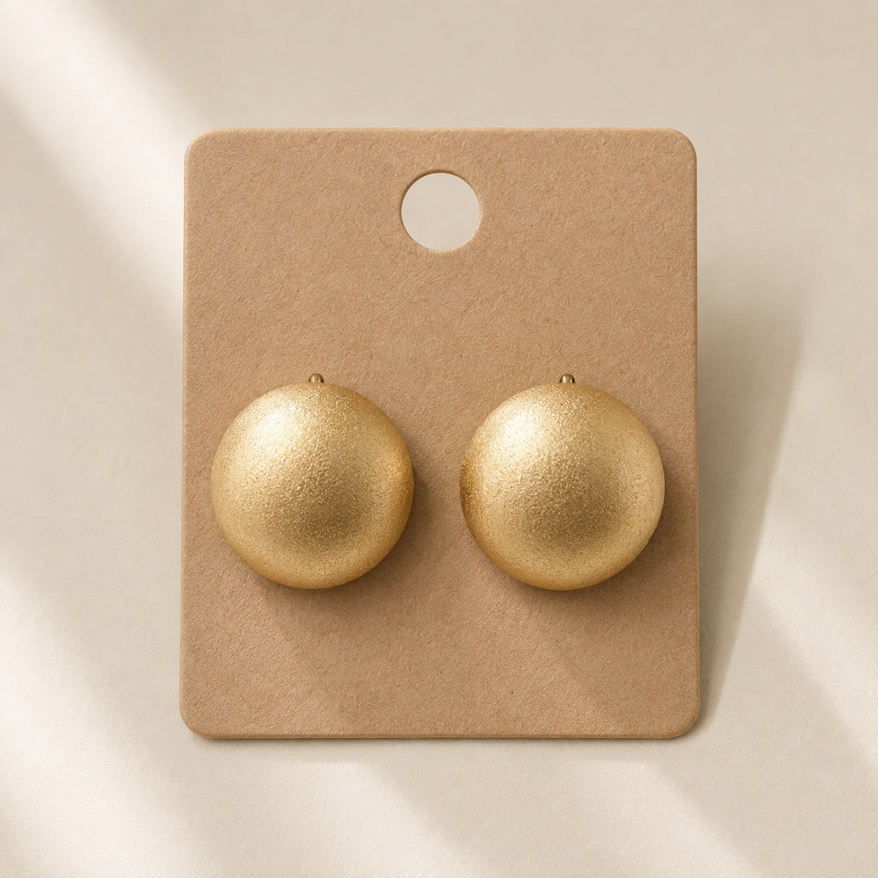 Time4Me gold matte half-sphere stud earrings made of stainless steel on a display card