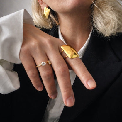 Time4Me gold adjustable ring with a melted metal texture worn by a woman in a black blazer and white shirt