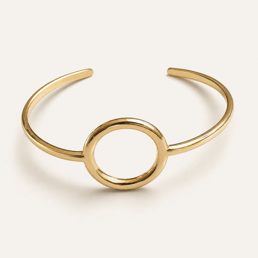Time4Me minimalist gold-tone open cuff bracelet featuring a central circular design in polished stainless steel.