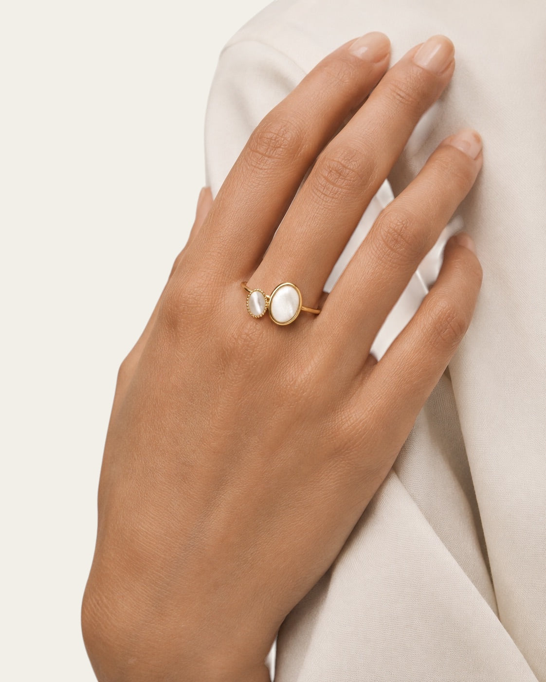 Time4Me adjustable gold stainless steel ring featuring two oval mother of pearl accents worn on a woman's hand