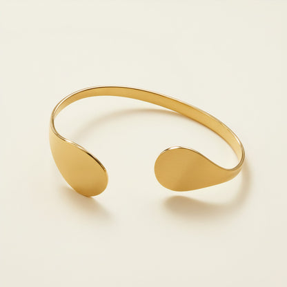 Time4Me gold-toned stainless steel open cuff bracelet with teardrop-shaped ends on a neutral background.