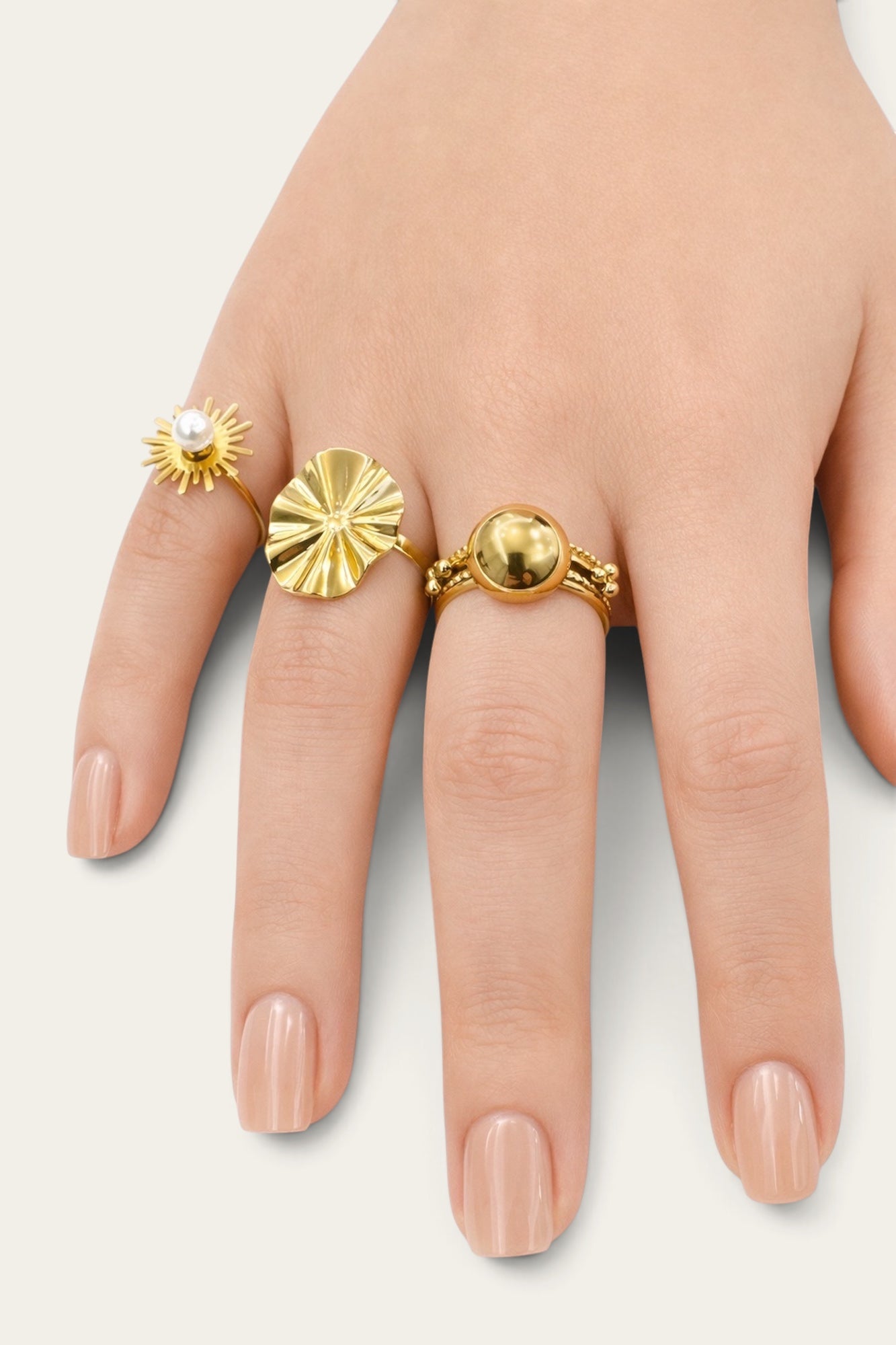 Time4Me gold oval wave ring worn on a hand alongside other gold rings with pearl and spherical accents