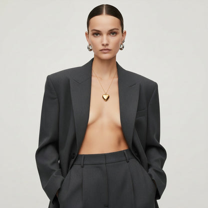 Time4Me gold stainless steel necklace with a polished puffy heart pendant worn by a model in a grey blazer