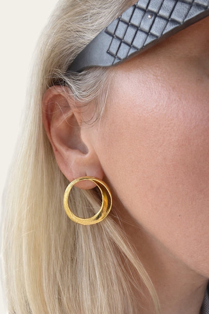Time4Me gold spiral hoop earrings made of stainless steel worn by a woman with blonde hair