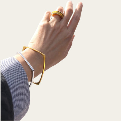 Time4Me gold square stainless steel bracelet worn on a wrist alongside a silver bracelet and a gold ring