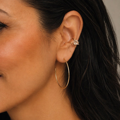 Time4Me gold hoop earrings with thin circular design worn by a woman with an ear cuff