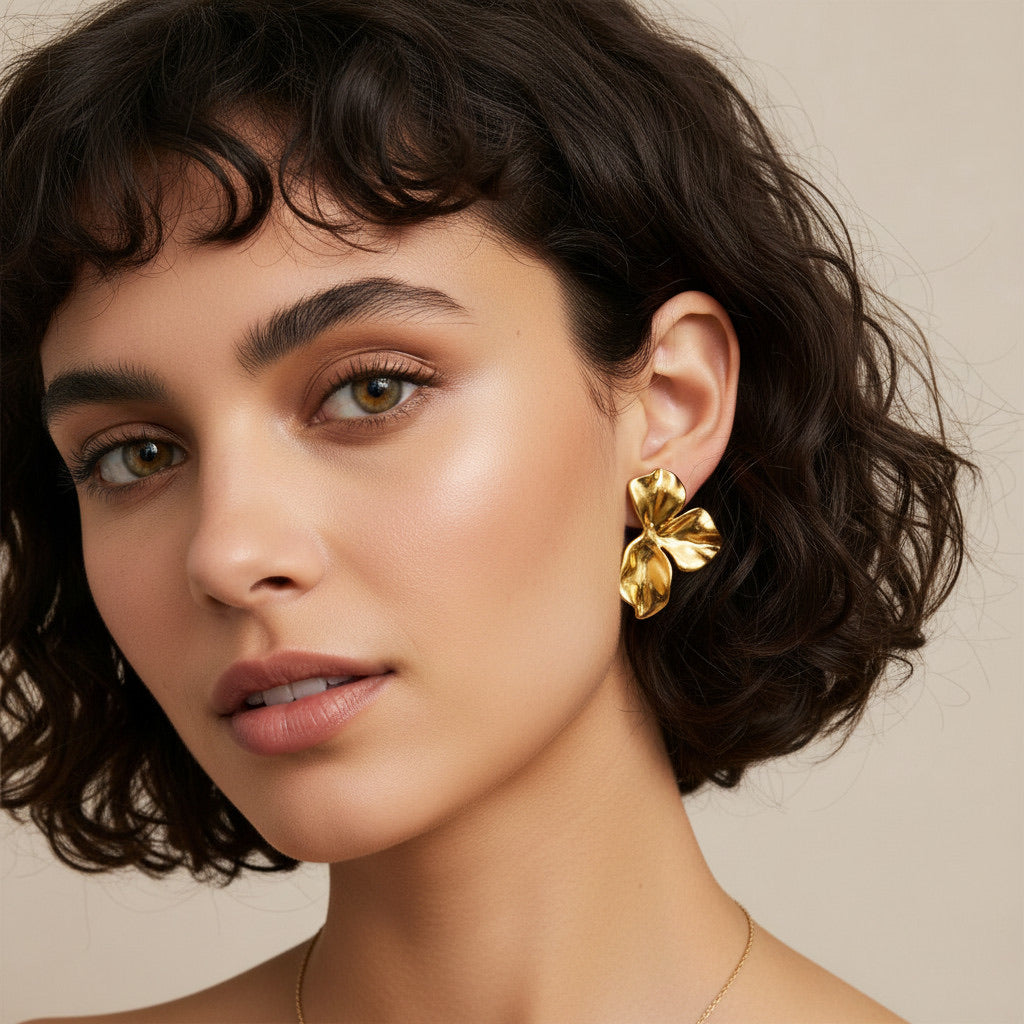 Time4Me gold stainless steel earrings with wavy petal design worn by a woman with short dark hair