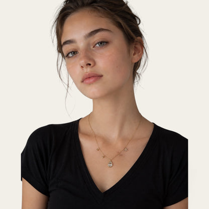 Colier Time4Me multicharm auriu din otel inoxidabil purtat de o tanara cu tricou negru