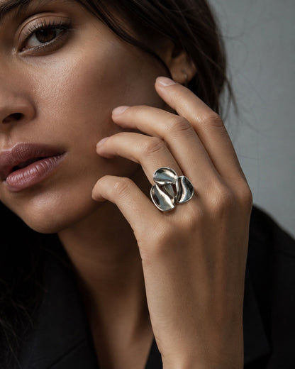 Time4Me wide silver-tone adjustable ring featuring a sculptural three-petal floral design worn on a woman's finger