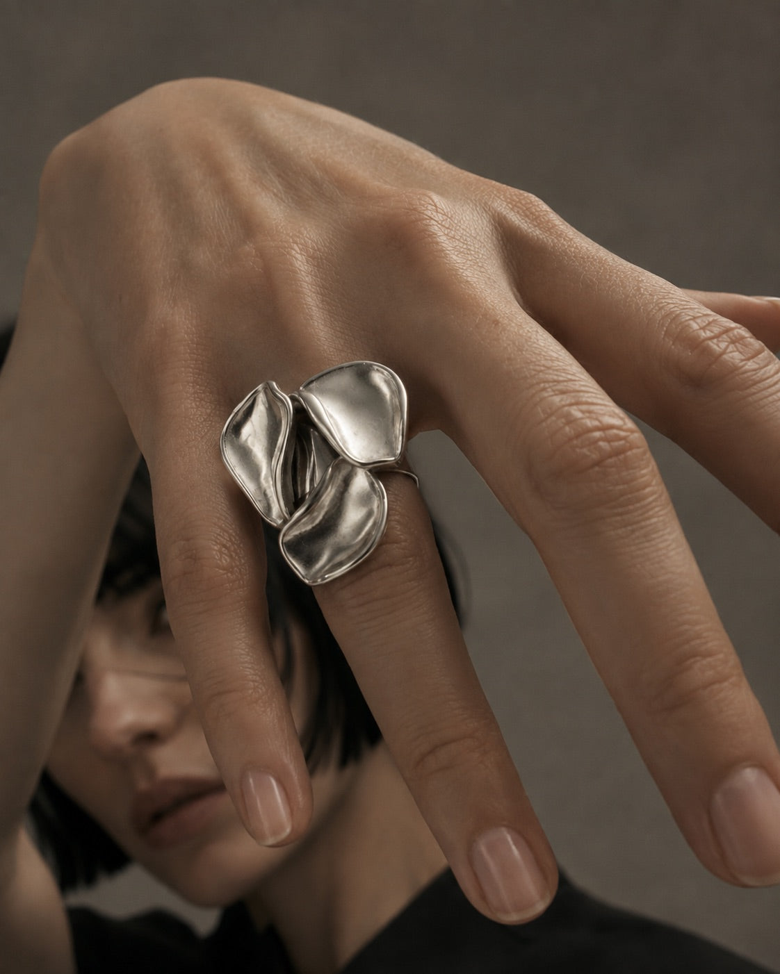 Time4Me adjustable silver-tone stainless steel ring featuring a sculptural three-petal floral design on a hand