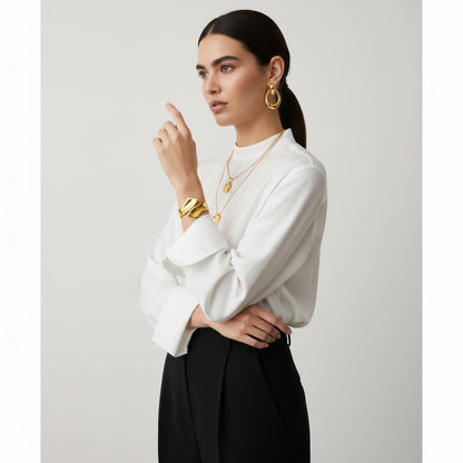 Time4Me sculptural gold open cuff bracelet worn by a model in a white blouse and black trousers