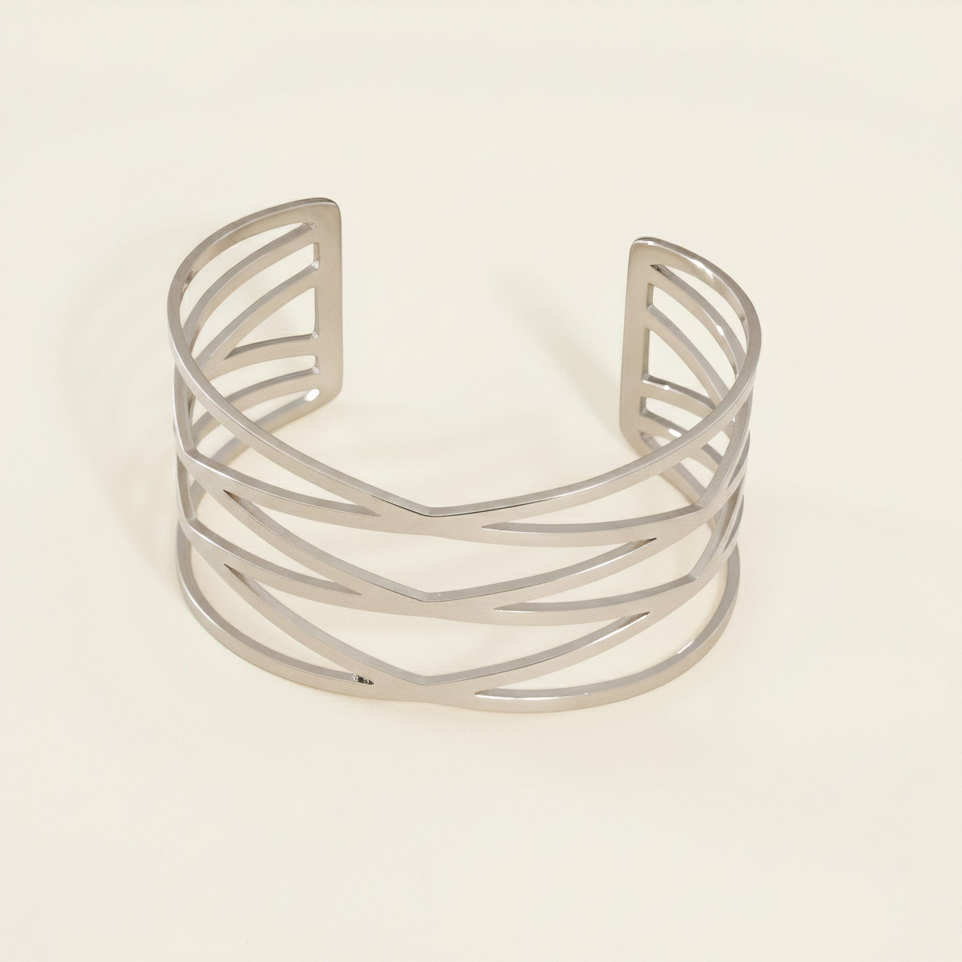 Time4Me silver-tone stainless steel open cuff bracelet featuring a stylish woven-look geometric cutout design.