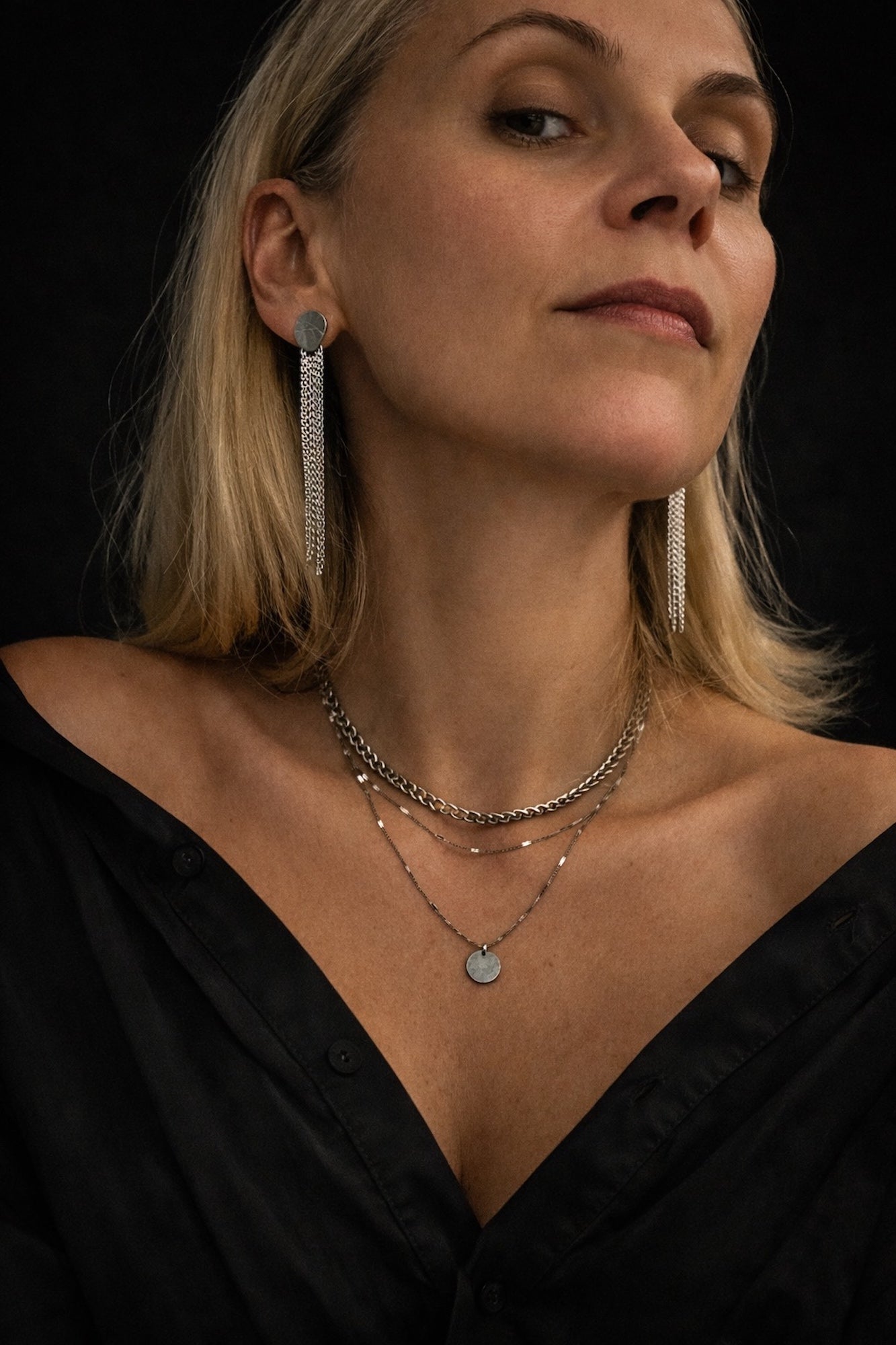 Time4Me silver stainless steel dangle earrings with chain fringe worn by a woman with a layered necklace