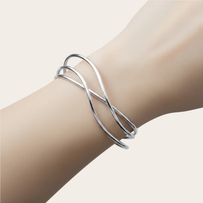 Time4Me silver open cuff bracelet with elegant crisscross lines worn on a wrist, made of durable stainless steel.
