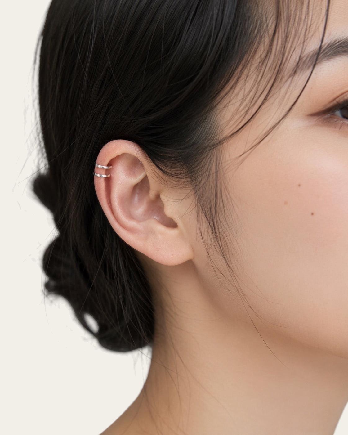 Time4Me silver double ring ear cuff worn on a woman's ear, minimalist stainless steel jewelry design.