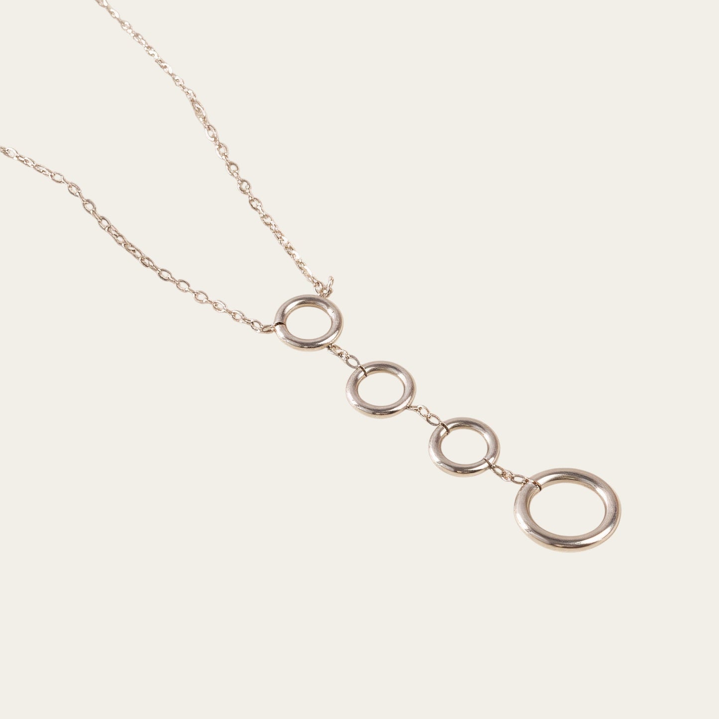 Time4Me silver-tone stainless steel necklace featuring four vertically aligned circular pendants on a delicate chain.