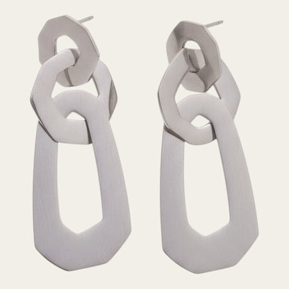 Time4Me silver-toned long earrings featuring three interconnected geometric shapes made of stainless steel.