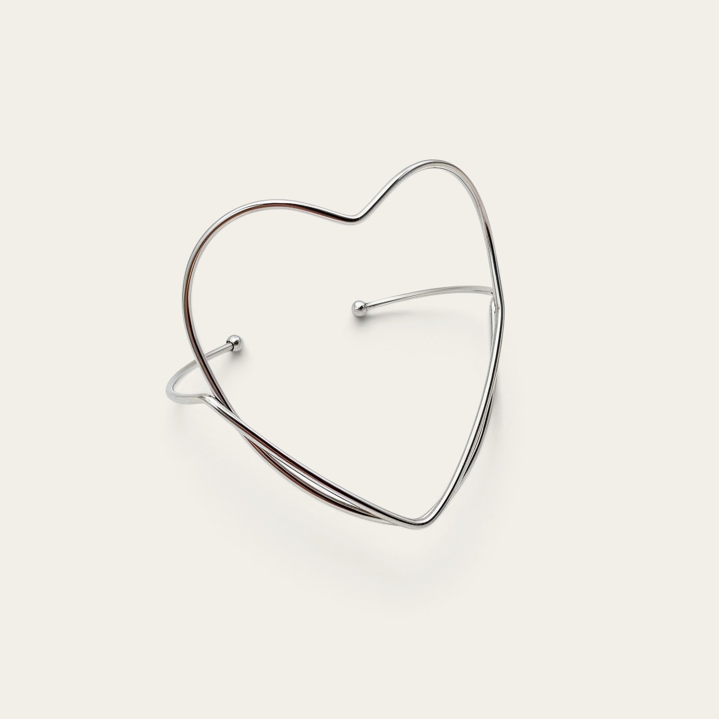Time4Me silver-tone stainless steel open cuff bracelet featuring a minimalist heart-shaped design.