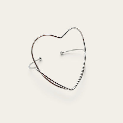 Time4Me silver-tone stainless steel open cuff bracelet featuring a minimalist heart-shaped design.