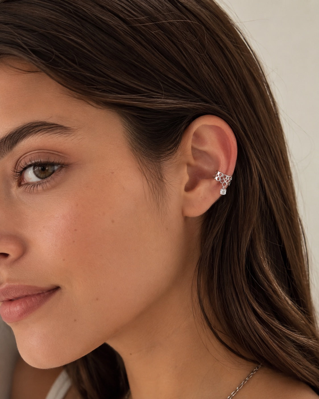 Time4Me silver ear cuff with honeycomb pattern and dangling crystal charm worn on a woman's ear