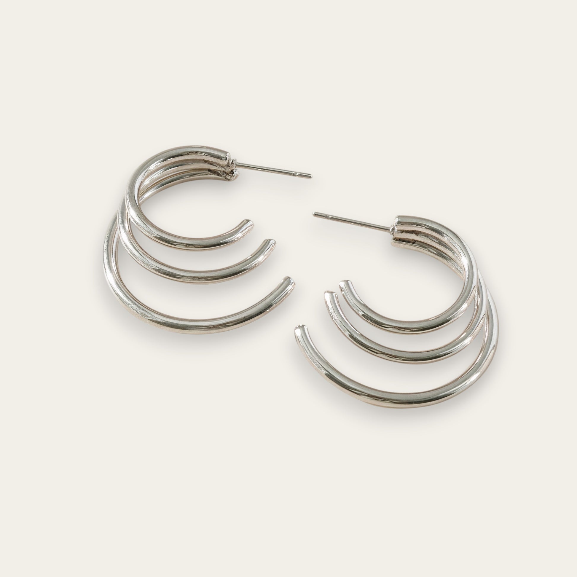 Time4Me silver-tone stainless steel hoop earrings featuring a layered triple-hoop design on a neutral background.