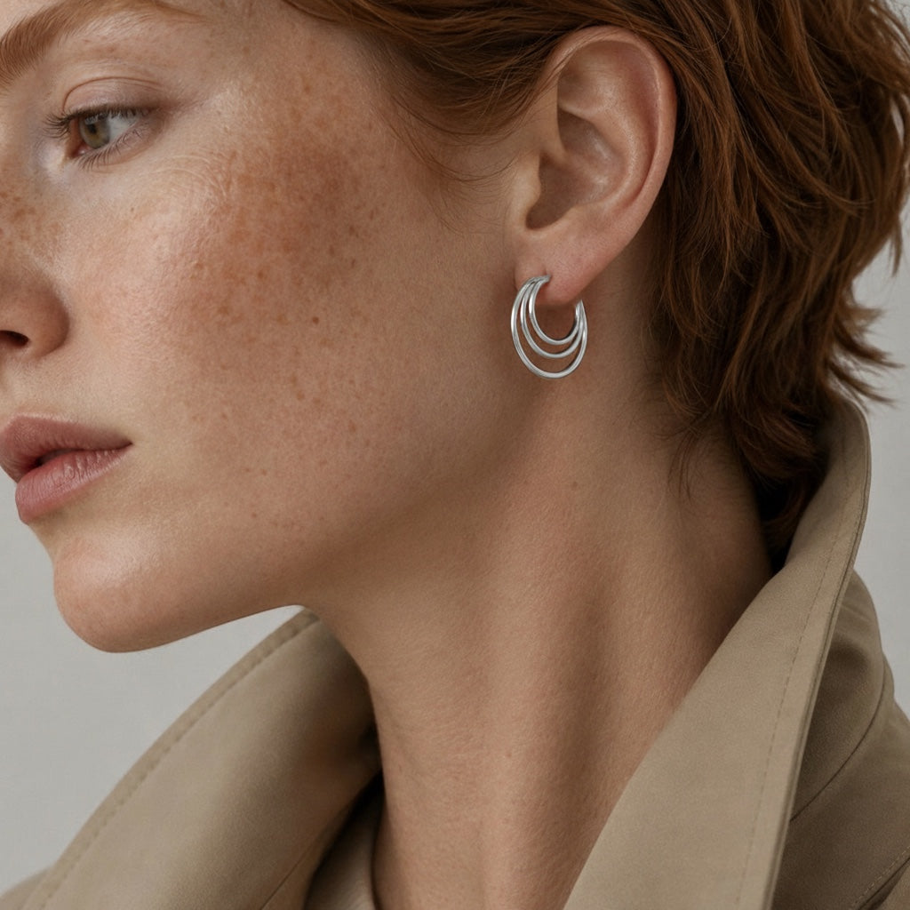 Time4Me silver layered hoop earrings worn by a woman with red hair and a beige trench coat