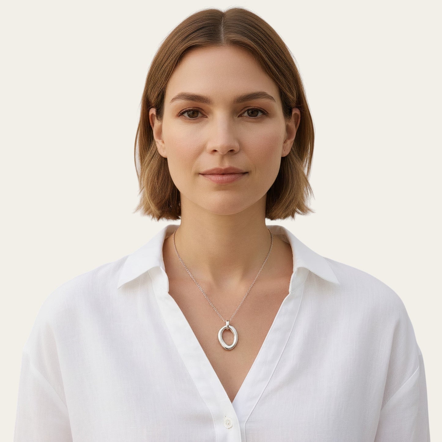 Time4Me silver necklace with a smooth oval pendant worn by a woman in a white shirt