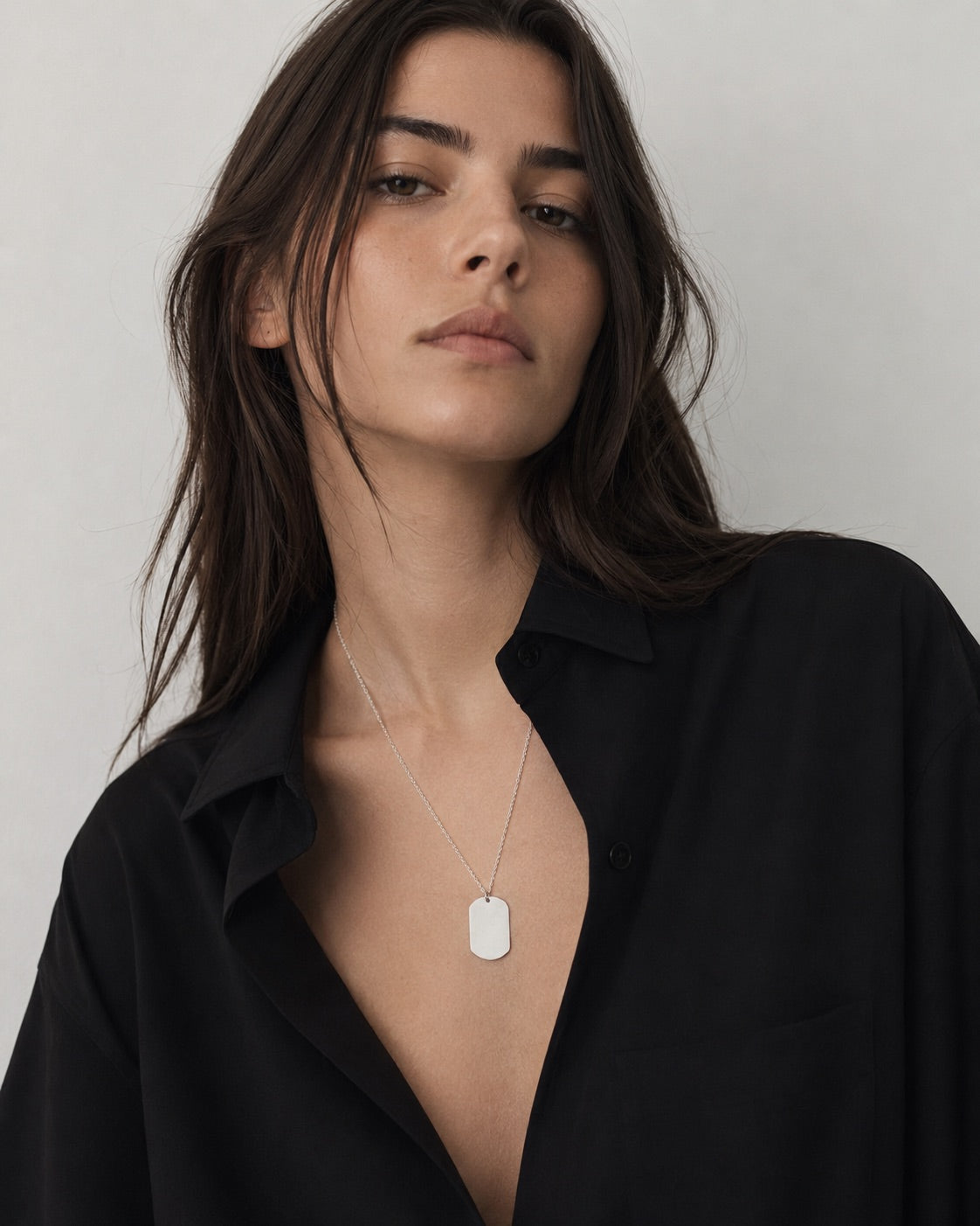Time4Me silver stainless steel necklace with a rounded rectangular pendant worn by a woman in a black shirt