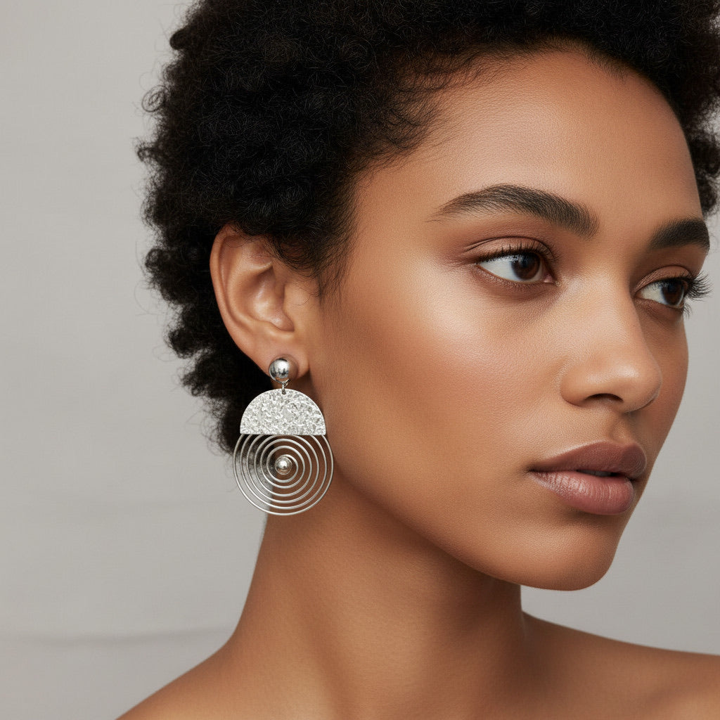 Time4Me silver spiral earrings worn by a woman with short dark hair, featuring a textured semi-circle design.