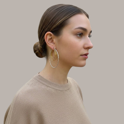 Time4Me two-tone oval hoop earrings with textured gold and silver finish worn by a woman in profile