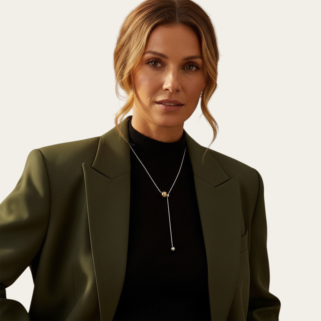 Time4Me two-tone Y-necklace in silver and gold stainless steel with sliding beads worn by a woman in a green blazer.