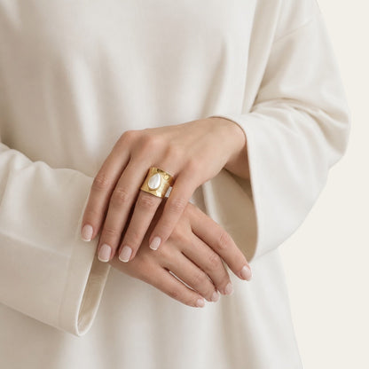Time4Me wide gold-tone adjustable stainless steel ring featuring a white teardrop stone worn on a woman's hand