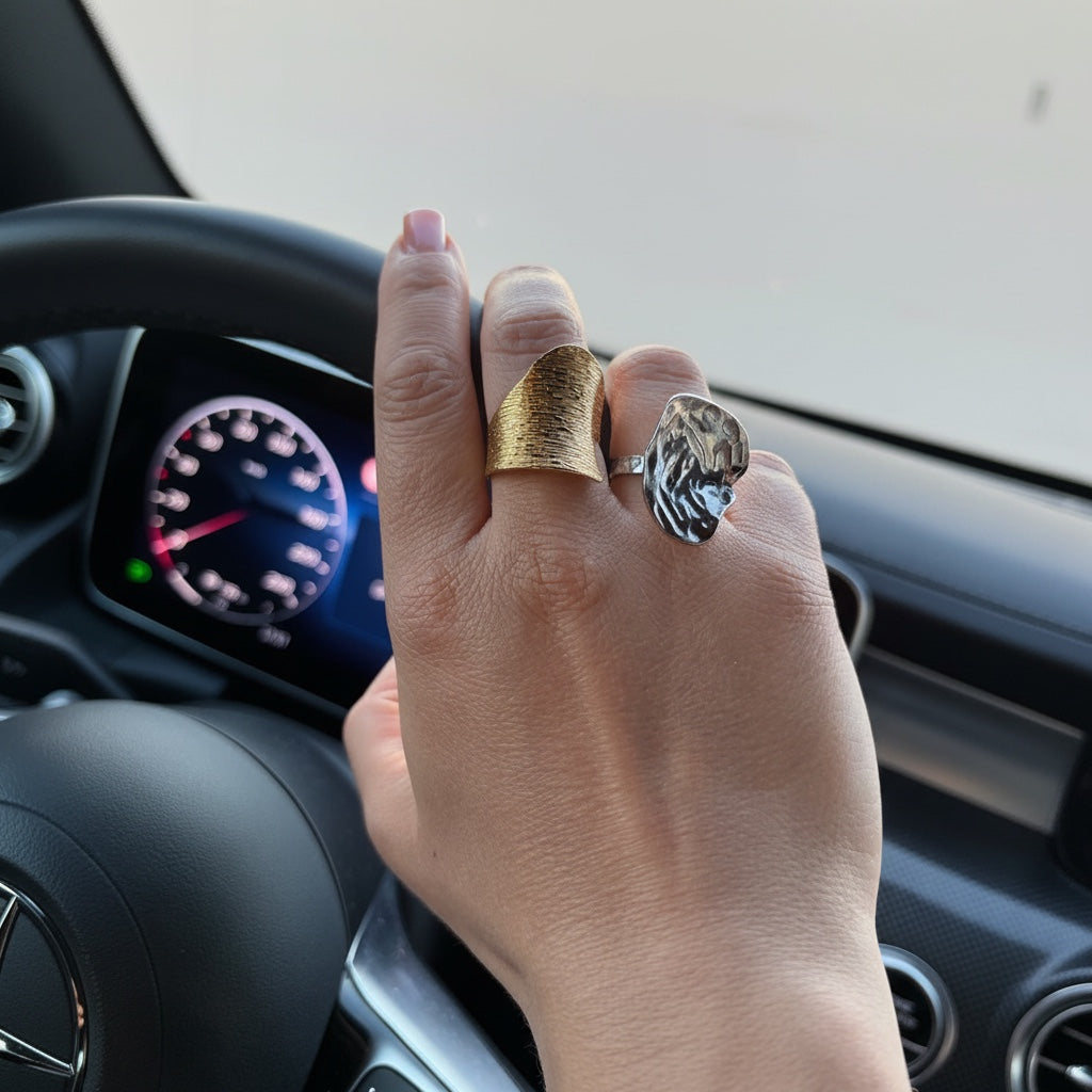 Time4Me wide gold ring with engraved lines worn on a hand while driving, paired with a silver textured ring
